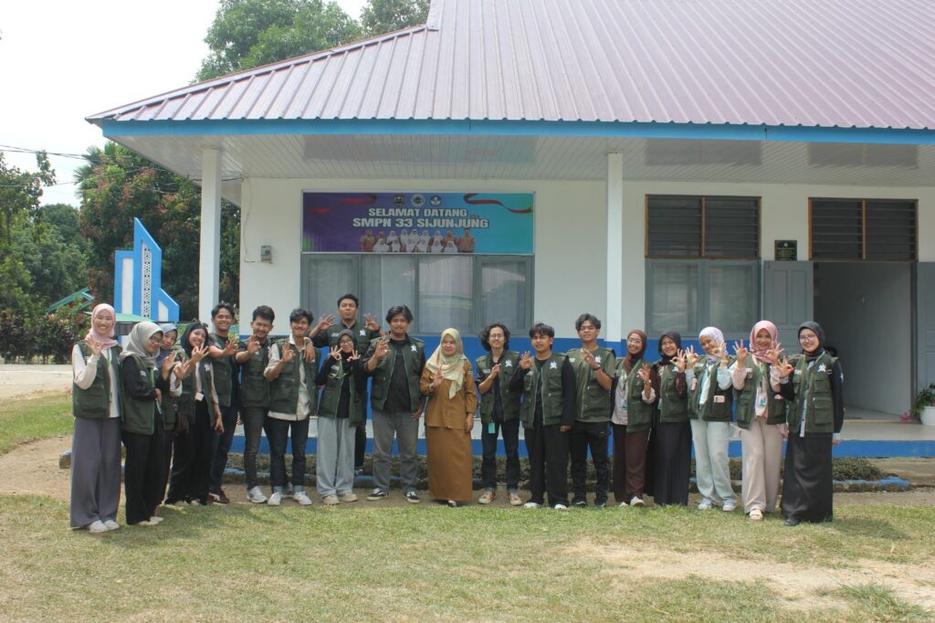 Foto bersama rombongan mahasiswa KKN Universitas Andalas dengan perwakilan siswa dan guru di depan gedung SMPN 33 Sijunjung usai agenda psikoedukasi kenakalan remaja.
